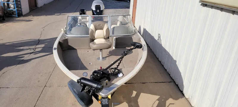 Slide: The Image of 2004 Sylvan F 1800 Avenger boat with seating and motor, parked on concrete. - 2