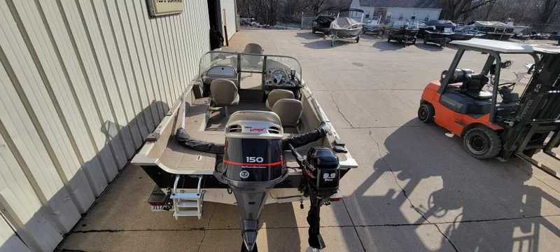 Slide: The Image of 2004 Sylvan F 1800 Avenger boat with outboard motor in a parking area. - 3