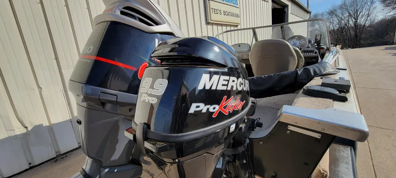 Slide: The Image of Outboard motors on a 2004 Sylvan F 1800 Avenger boat, parked near a building. - 6