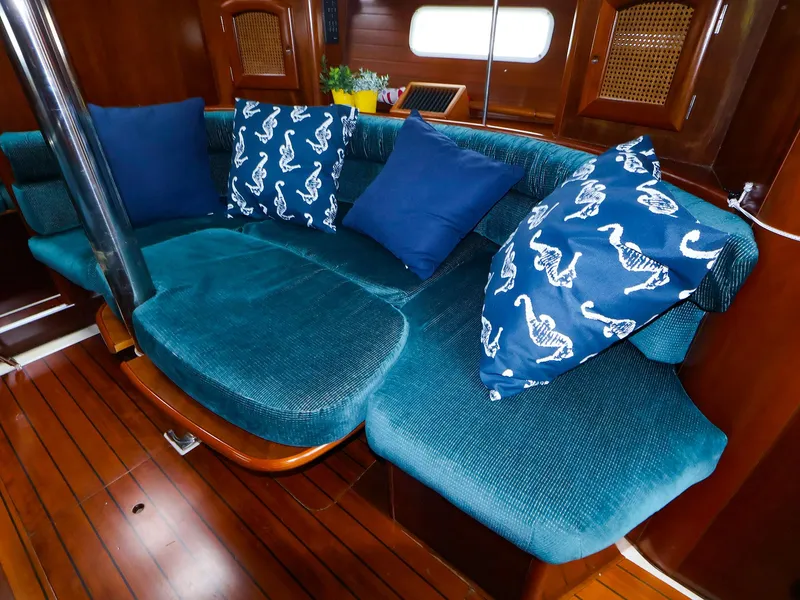Slide: The Image of Interior of 1999 Beneteau 361 yacht with teal seating and decorative pillows. - 25