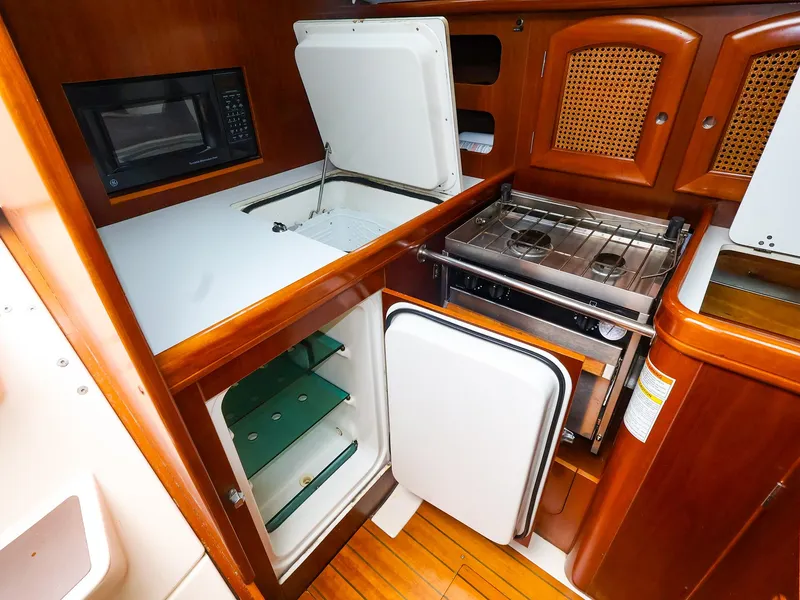 Slide: The Image of 1999 Beneteau 361 yacht kitchen with stove, fridge, and microwave. - 29