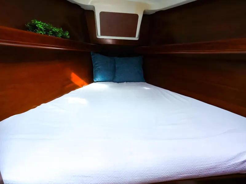 Slide: The Image of Cozy cabin interior of 1999 Beneteau 361 sailboat with bed and pillows. - 40