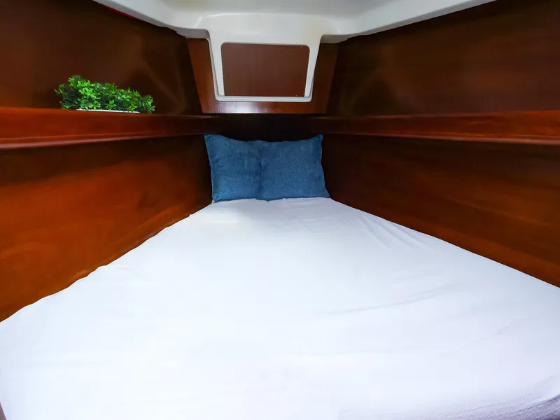Slide: The Image of Cozy cabin interior of 1999 Beneteau 361 sailboat with wooden finish and bedding. - 42