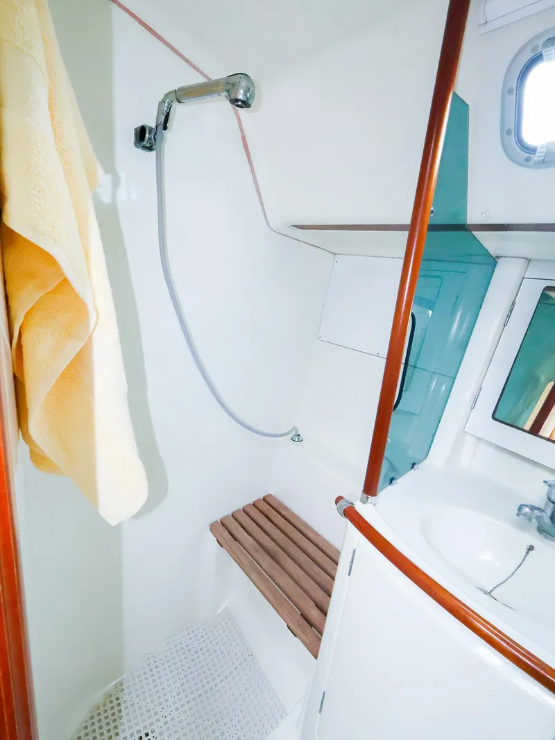 Slide: The Image of 1999 Beneteau 361 yacht bathroom with shower, sink, and wooden bench. - 47