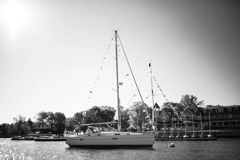 Slide: The Image of Sailboat Beneteau 361 (1999) docked near waterfront homes, under clear sky. - 5