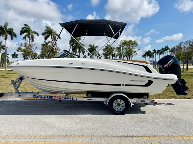 Slide: The Image of 2021 Bayliner VR5 OB boat on trailer, palm trees in background, sunny day. - 0