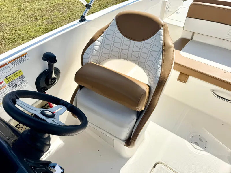 Slide: The Image of 2021 Bayliner VR5 OB boat interior with steering wheel and cushioned seat. - 11