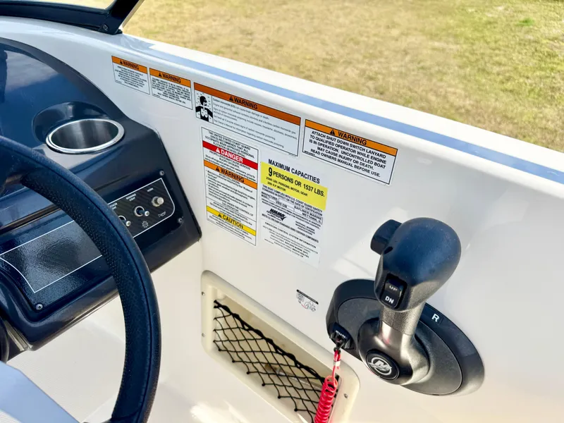 Slide: The Image of 2021 Bayliner VR5 OB boat dashboard with control lever and safety warnings. - 15