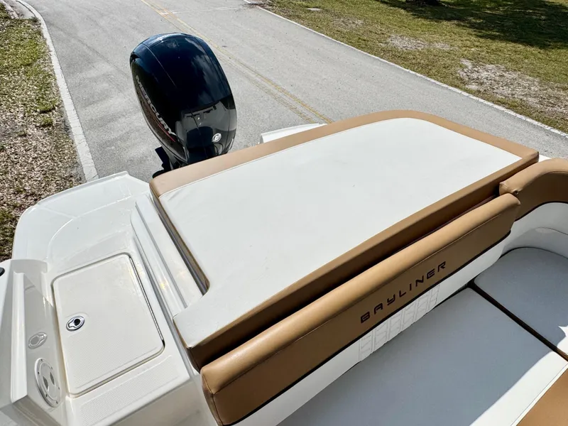 Slide: The Image of 2021 Bayliner VR5 OB boat with tan seating and outboard motor on a sunny day. - 21