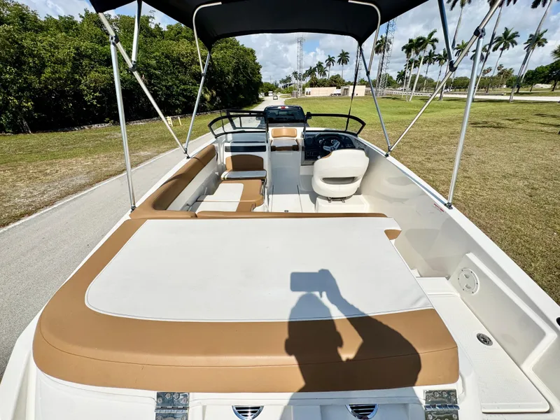 Slide: The Image of 2021 Bayliner VR5 OB boat with spacious seating and canopy, parked on a sunny day. - 23