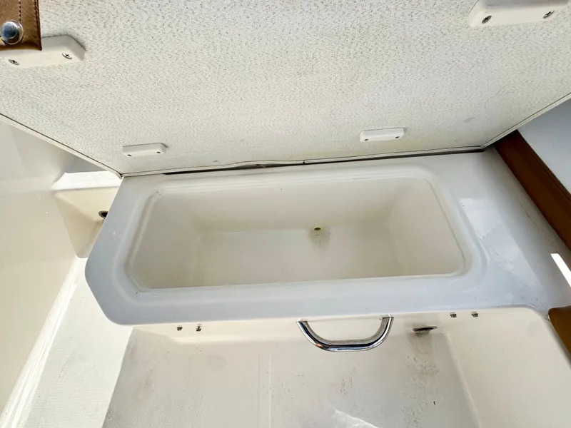 Slide: The Image of 2021 Bayliner VR5 OB boat storage compartment with open lid, showcasing interior space. - 24