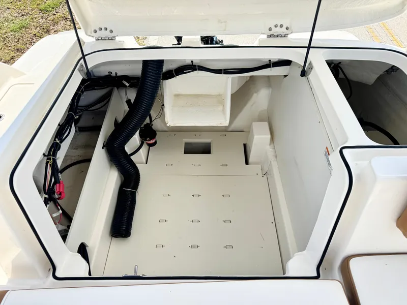 Slide: The Image of 2021 Bayliner VR5 OB boat storage compartment with open hatch, showcasing interior space and wiring. - 25
