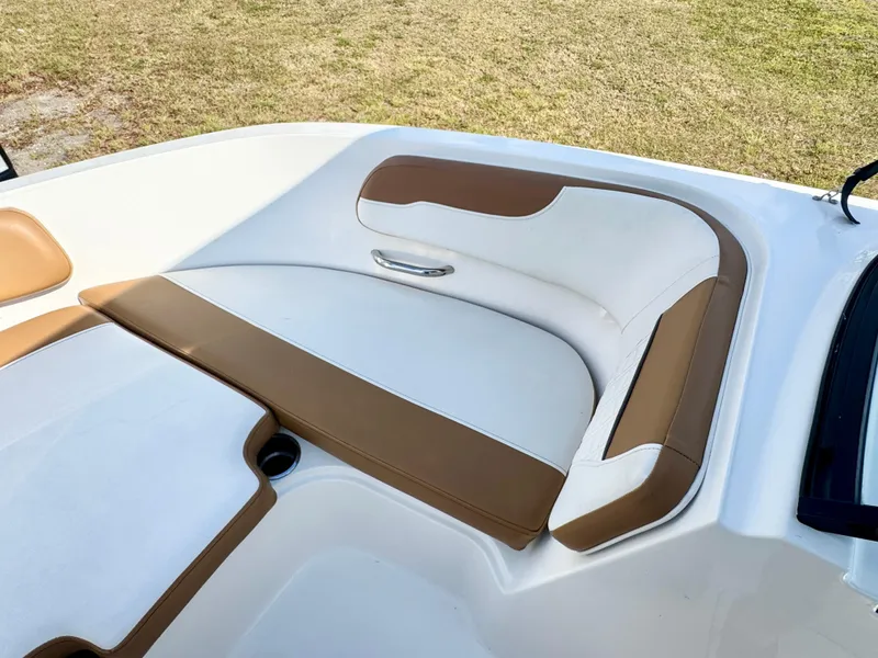 Slide: The Image of 2021 Bayliner VR5 OB boat interior with white and brown cushioned seating. - 9