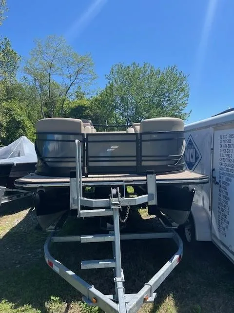 Slide: The Image of 2023 Starcraft SLS3 Q DH pontoon boat on trailer, surrounded by trees and clear blue sky. - 7