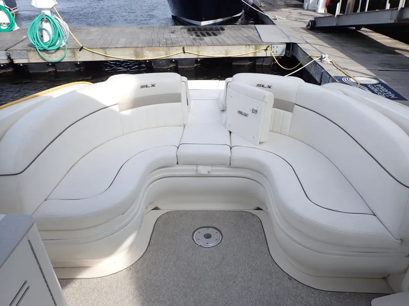 Slide: The Image of 2010 Sea Ray 300 SLX boat with spacious white seating at the dock. - 10