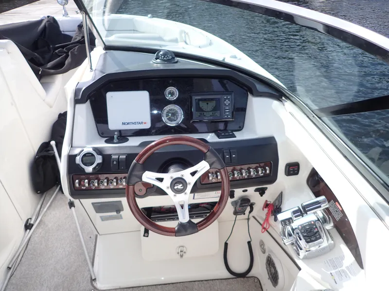 Slide: The Image of 2010 Sea Ray 300 SLX boat dashboard with steering wheel and navigation controls. - 11