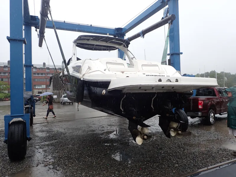 Slide: The Image of Sea Ray 300 SLX 2010 boat lifted by crane in a marina setting. - 23
