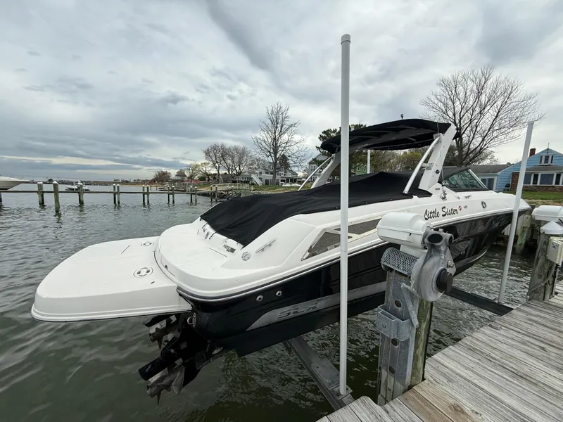 Slide: The Image of 2010 Sea Ray 300 SLX boat docked, covered, with scenic waterfront background. - 3
