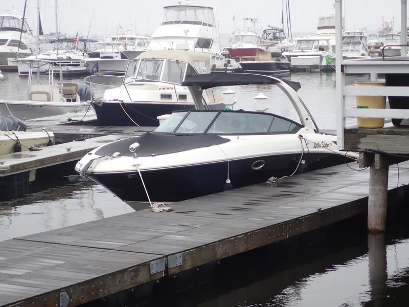 Slide: The Image of 2010 Sea Ray 300 SLX boat docked at a marina with other vessels. - 7