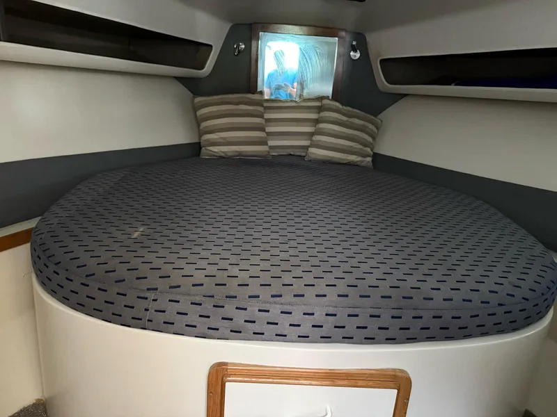 Slide: The Image of Cozy cabin interior of 1995 Catalina Islander 34 with striped pillows and round bed. - 10