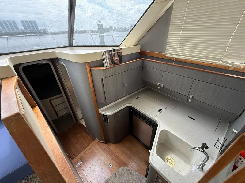 Slide: The Image of Interior of 1995 Catalina Islander 34 yacht, featuring compact kitchen with sink and cabinets. - 13