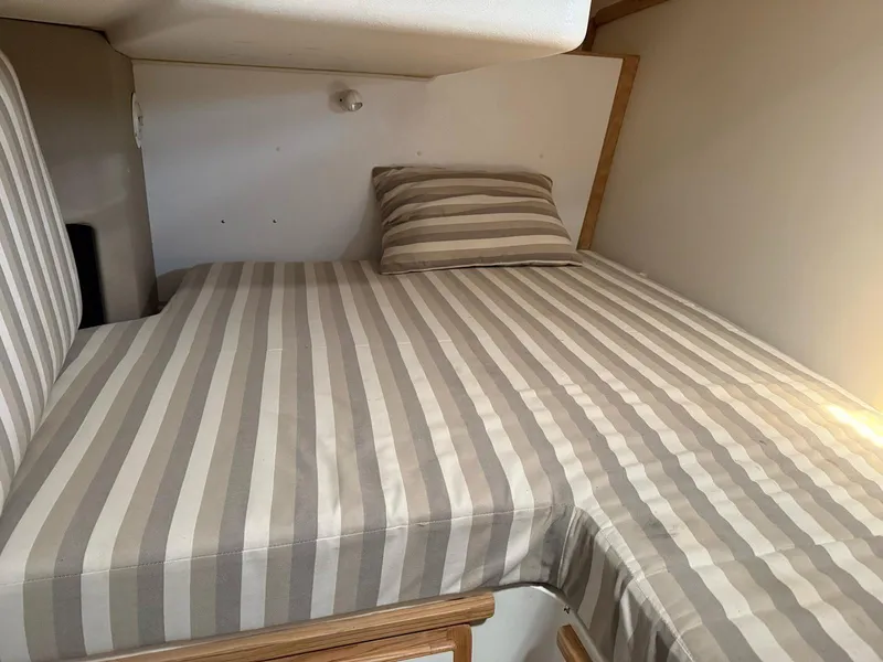 Slide: The Image of Striped bedding in a cozy cabin of a 1995 Catalina Islander 34 boat. - 16