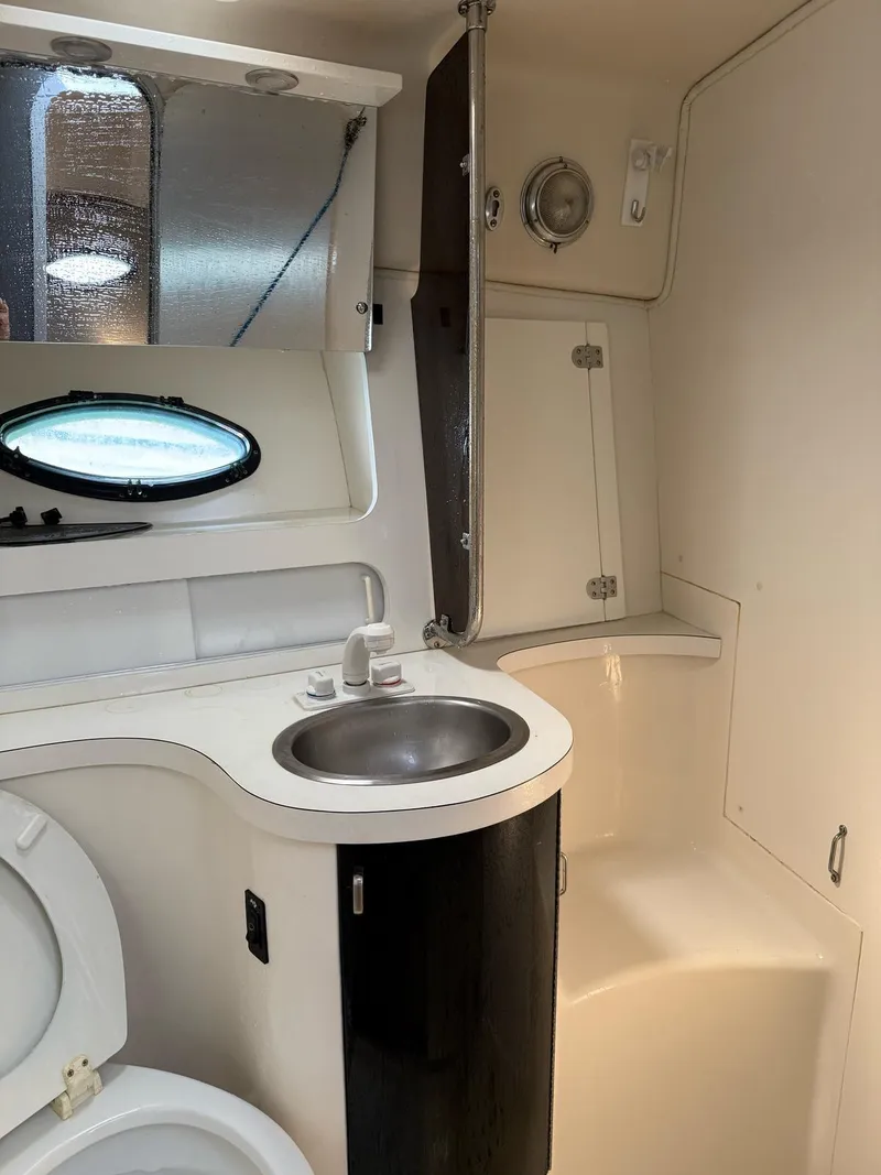 Slide: The Image of 1995 Catalina Islander 34 yacht bathroom with sink, toilet, and storage cabinets. - 18