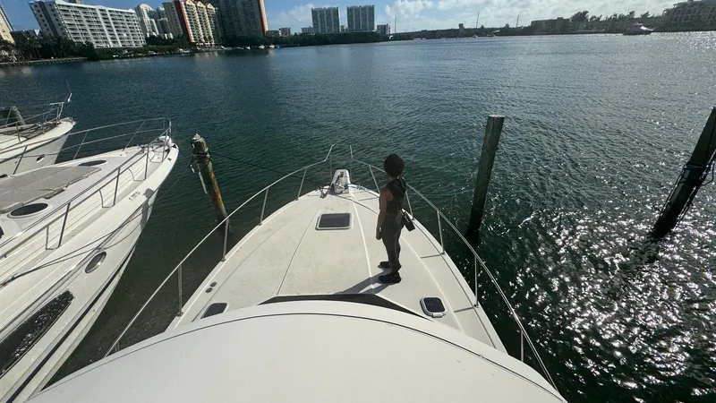 Slide: The Image of Person standing on a 1995 Catalina Islander 34 yacht, docked near waterfront buildings. - 6