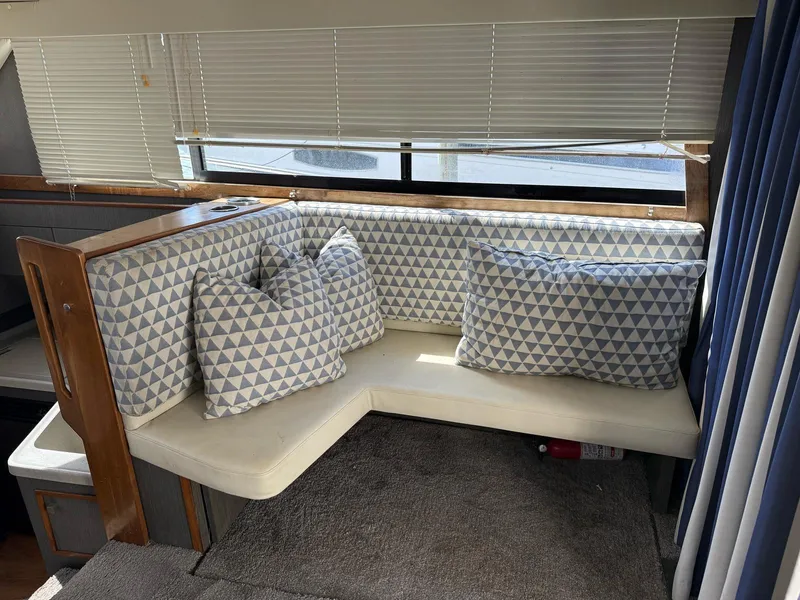 Slide: The Image of Cozy seating area in 1995 Catalina Islander 34 with geometric-patterned cushions and blinds. - 7