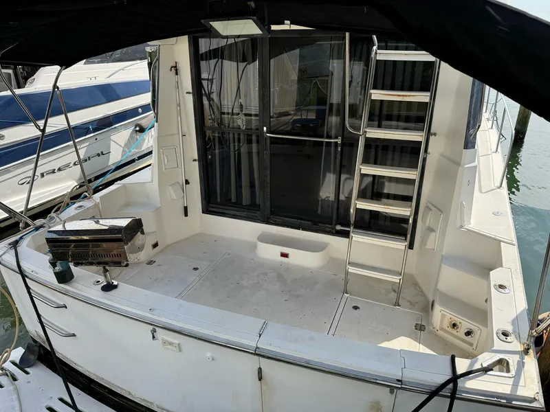 Slide: The Image of 1995 Catalina Islander 34 boat with spacious deck and ladder, docked at marina. - 9