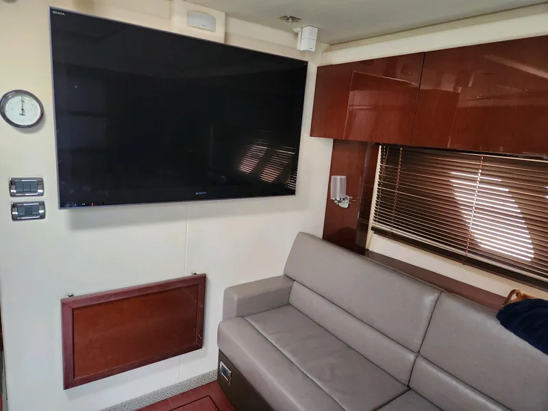 Slide: The Image of Interior of 2011 Sea Ray 540 Sundancer with TV, sofa, and wooden cabinets. - 12