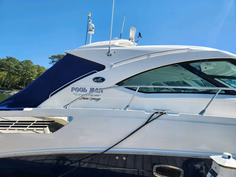 Slide: The Image of 2011 Sea Ray 540 Sundancer yacht with sleek design and blue accents under clear sky. - 8