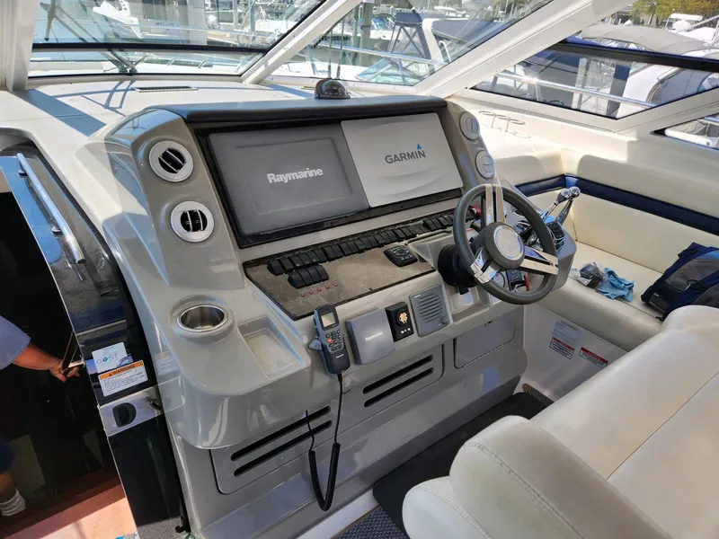 Slide: The Image of 2011 Sea Ray 540 Sundancer helm with Raymarine and Garmin displays, steering wheel, and controls. - 13