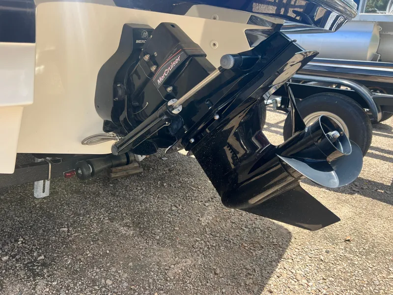 Slide: The Image of 2021 Monterey M22 boat with MerCruiser outboard motor, parked on gravel. - 2