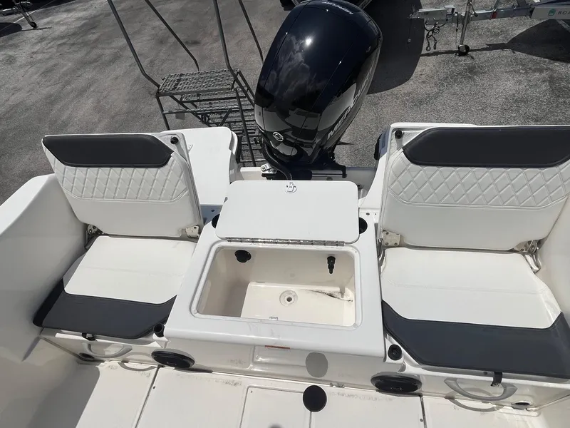 Slide: The Image of 2022 Bayliner Trophy T22CC boat interior with seating and motor, featuring modern design. - 10