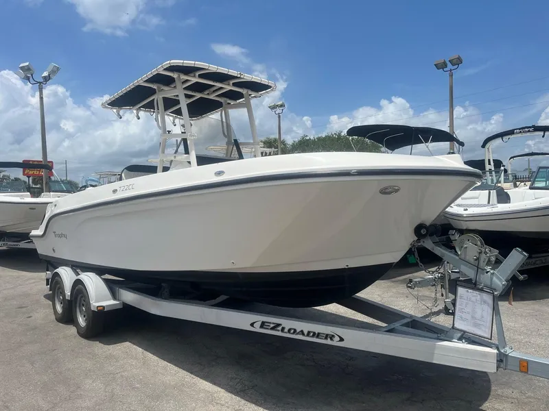 Slide: The Image of 2022 Bayliner Trophy T22CC boat on trailer under clear sky. - 2