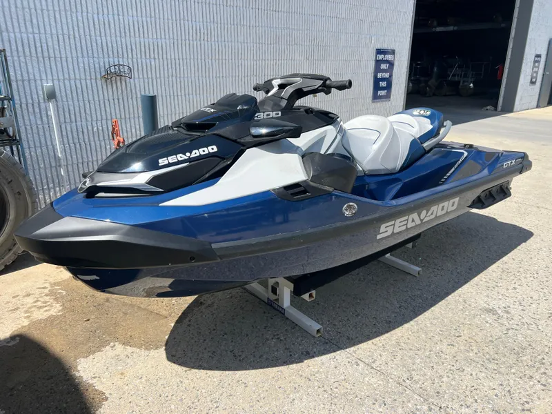 Slide: The Image of 2023 Sea-Doo GTX 300 jet ski in blue and white, parked outdoors. - 5