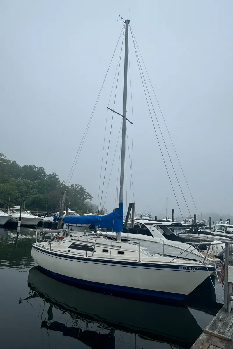 Slide: The Image of 1985 O'Day Sloop sailboat docked in a foggy marina. - 0