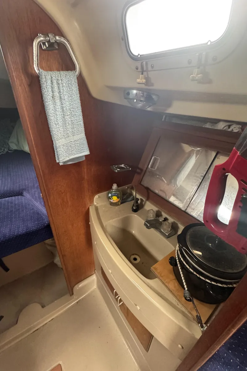 Slide: The Image of 1985 O'Day Sloop interior with compact sink and cozy cabin space. - 17
