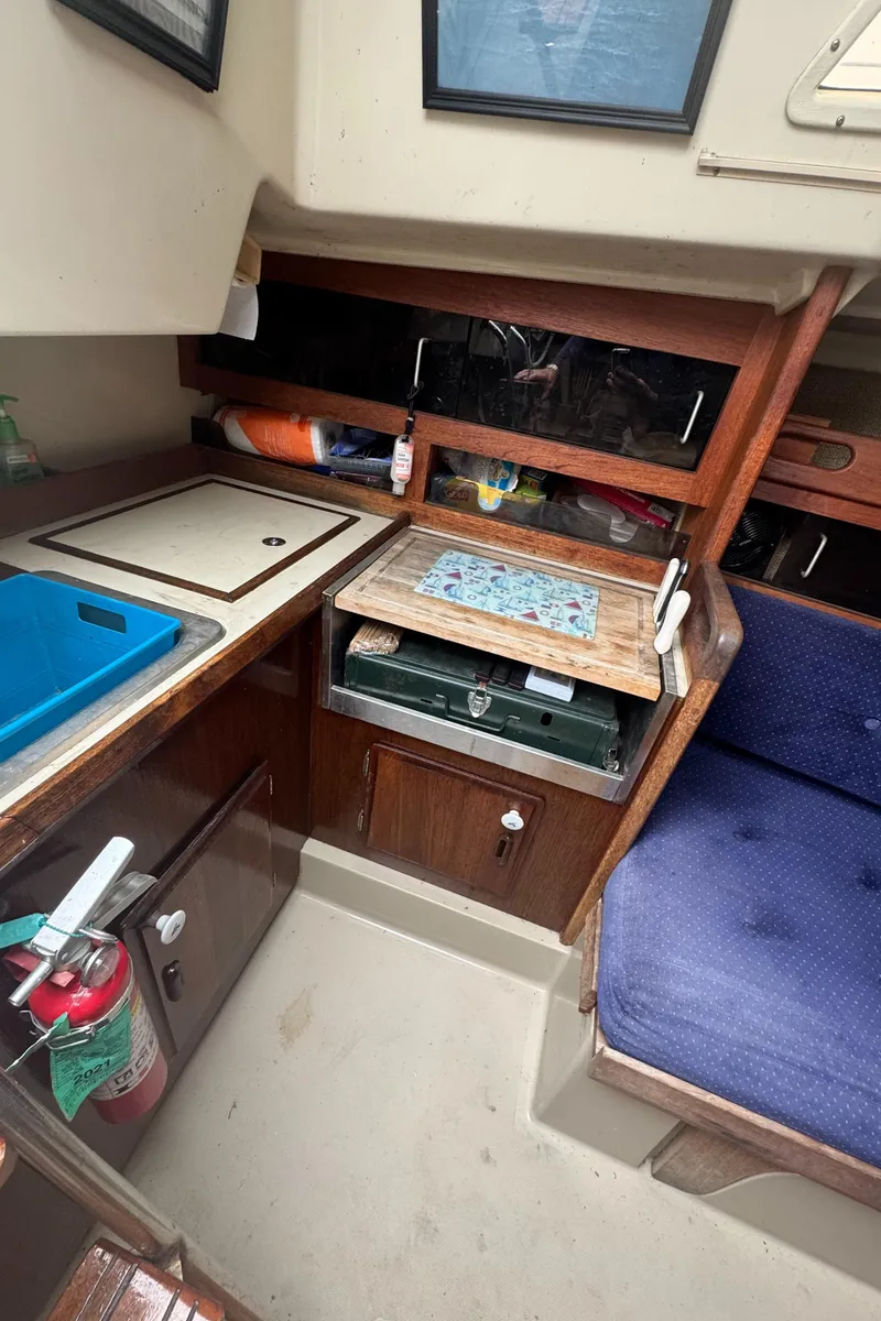 Slide: The Image of 1985 O'Day Sloop interior with compact kitchen and seating area. - 9