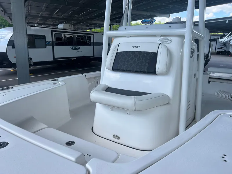 Slide: The Image of 2023 Tidewater 2110 boat interior with seating, parked under a covered area. - 12