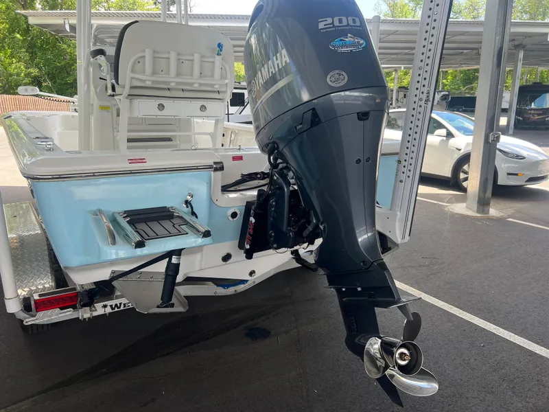 Slide: The Image of 2023 Tidewater 2110 boat with Yamaha 200 engine, parked under a canopy. - 6