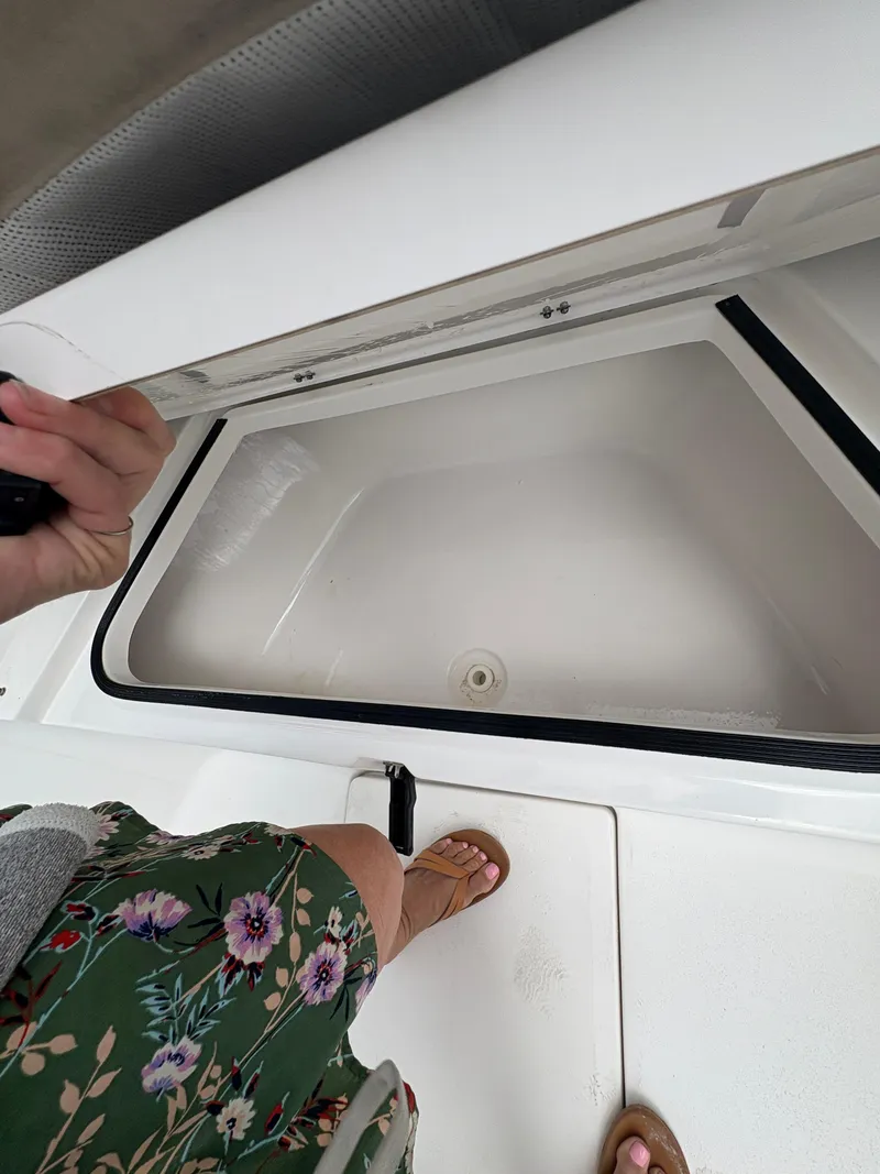 Slide: The Image of 2017 Sea Fox 206 Commander boat storage compartment with floral dress and sandals visible. - 23