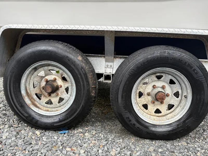Slide: The Image of Trailer wheels for 2017 Sea Fox 206 Commander on gravel surface. - 7