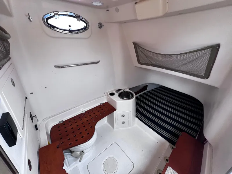 Slide: The Image of 2015 Grady-White 336 Canyon cabin interior with seating, porthole, and storage. - 10
