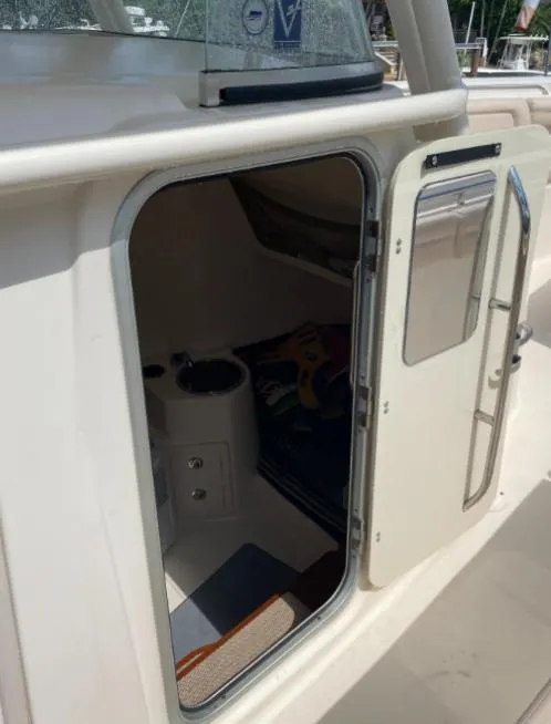 Slide: The Image of 2015 Grady-White 336 Canyon boat cabin entrance with open door, showing interior details. - 14