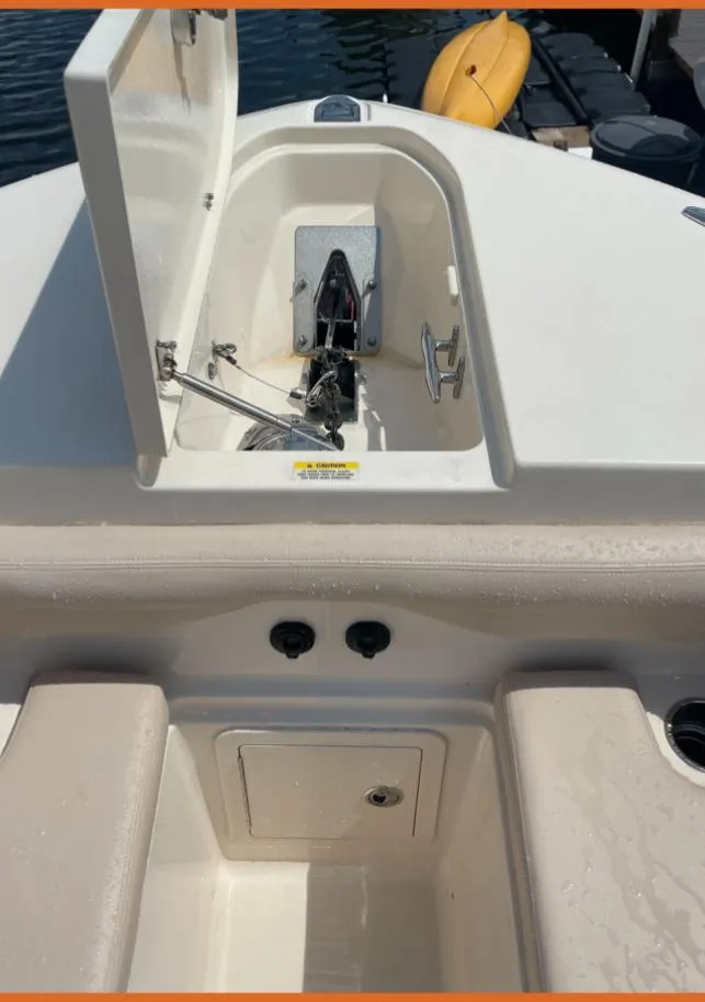 Slide: The Image of 2015 Grady-White 336 Canyon boat anchor compartment with open hatch, docked near a kayak. - 16