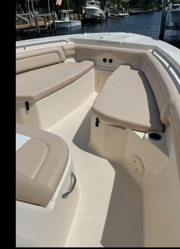 Slide: The Image of 2015 Grady-White 336 Canyon boat interior with beige seating and waterfront view. - 21