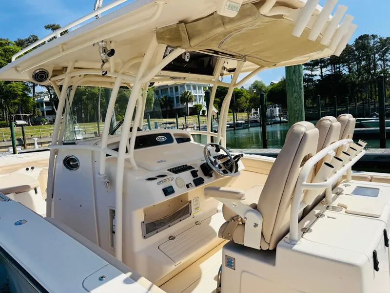 Slide: The Image of 2015 Grady-White 336 Canyon boat interior with helm, seats, and fishing rod holders. - 4