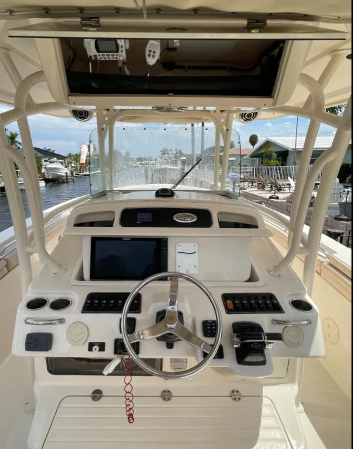 Slide: The Image of 2015 Grady-White 336 Canyon boat cockpit with steering wheel and navigation controls. - 9